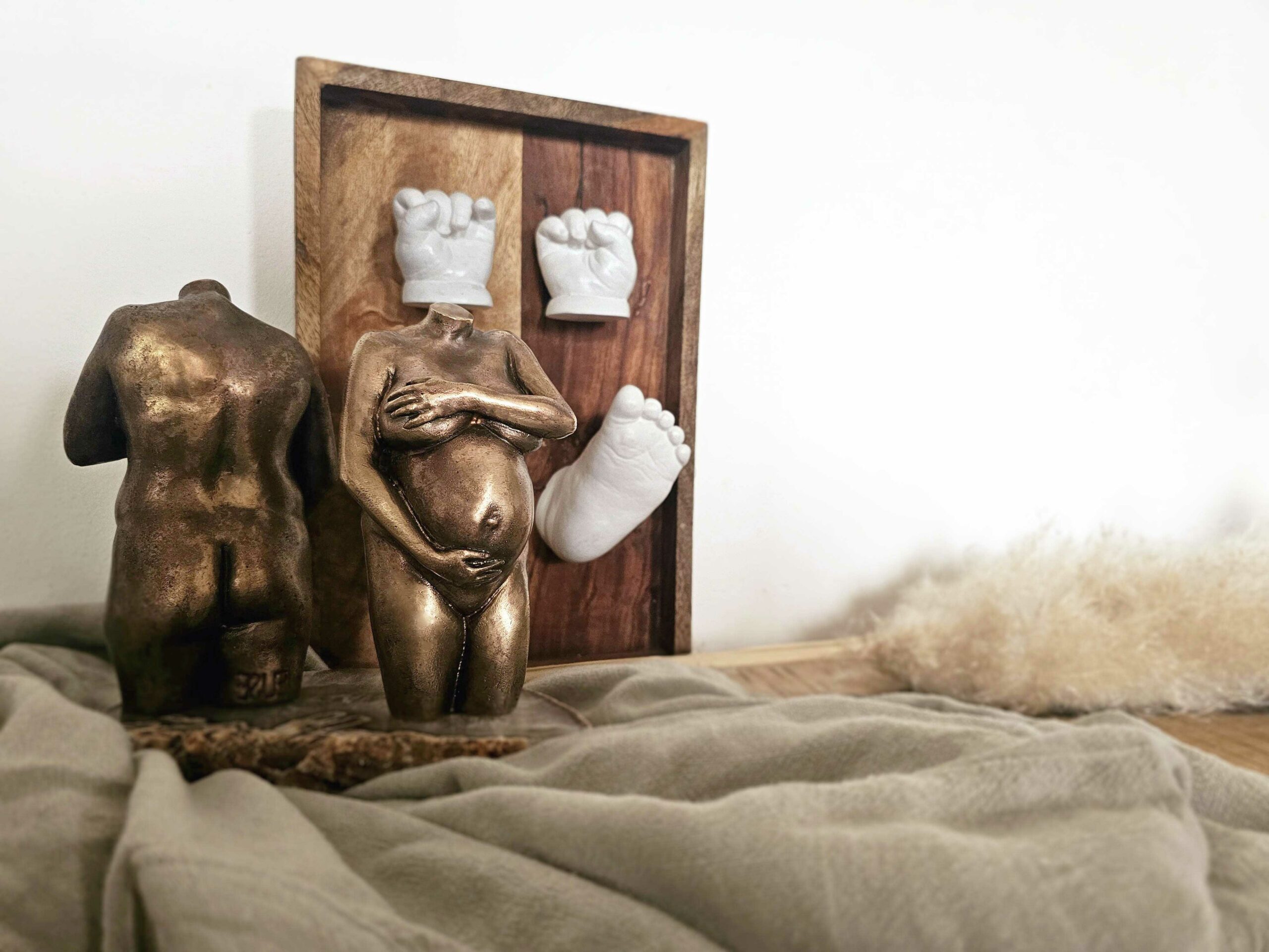 brons-3D-beeldje twee bronzen zwangerschapsbeeldjes en 3D lijstje met hand en voetafdrukjes. Van een van de twee beelden zie je de achterzijde