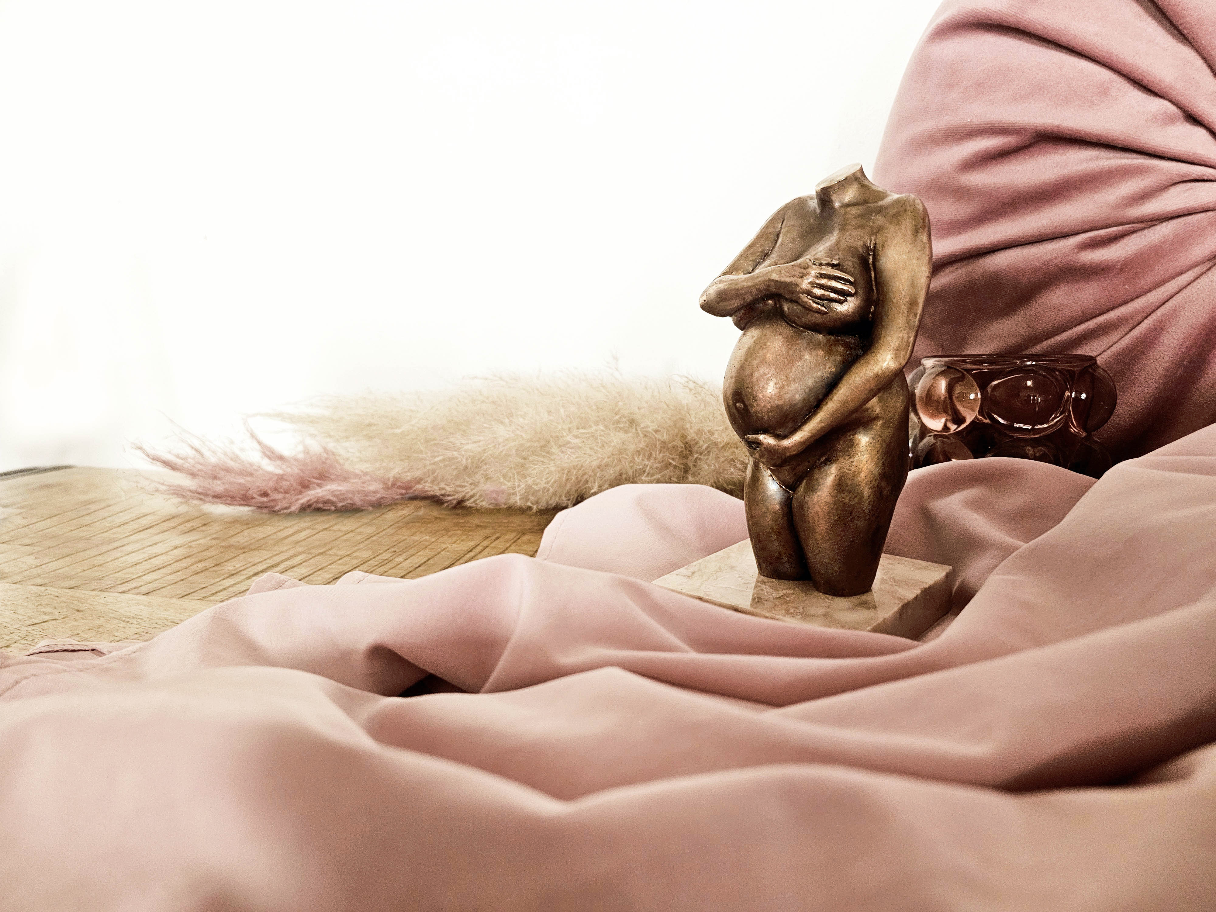 Buikbeeld Bronzen buikbeeld met oud roze achtergrond