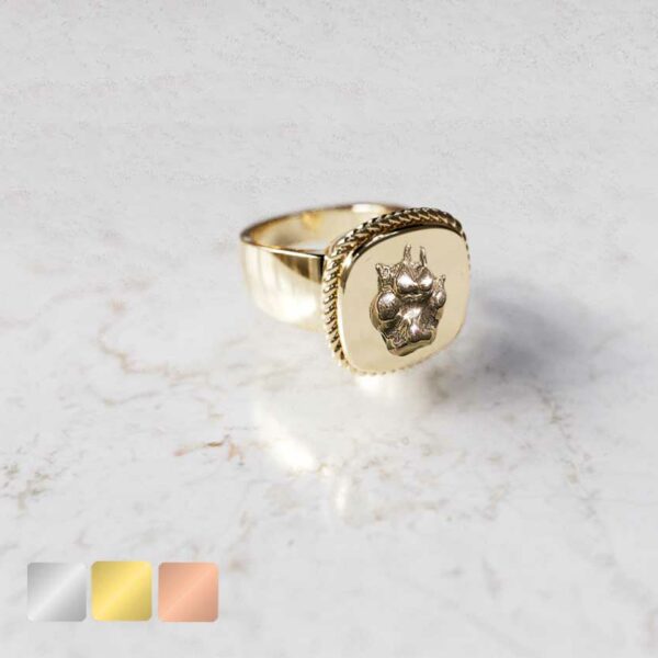 Vierkante ring met omlijsting met hondenpoot er op goudopties