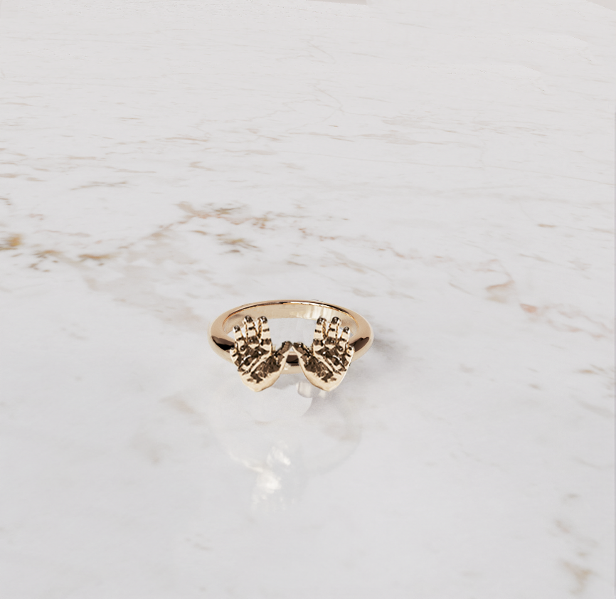 babyhandjes in een sieraad ring