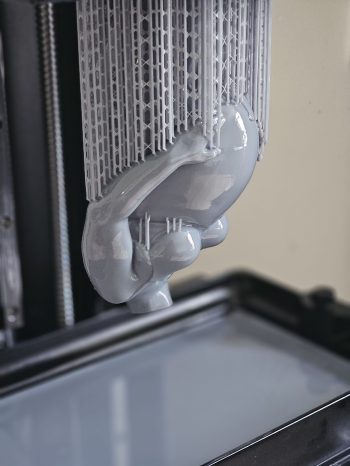 3D print hangt ondersteboven boven een resin 3D printer