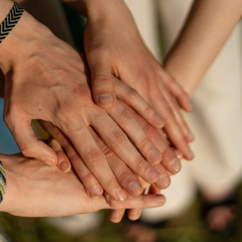groep mensen die handen op elkaar leggen en maken familie herinnering