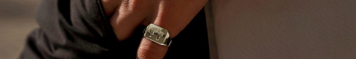 Gepersonaliseerde zegelring rechthoekig met voetstapjes aan pink in het zilver